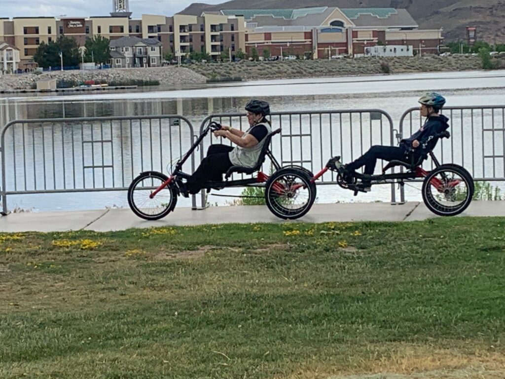 Two people riding adaptable bikes around the Sparks Marina.