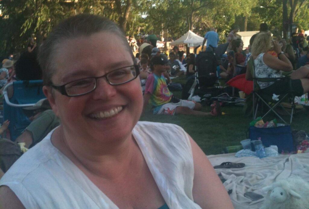 Gail sitting at an event in a park.