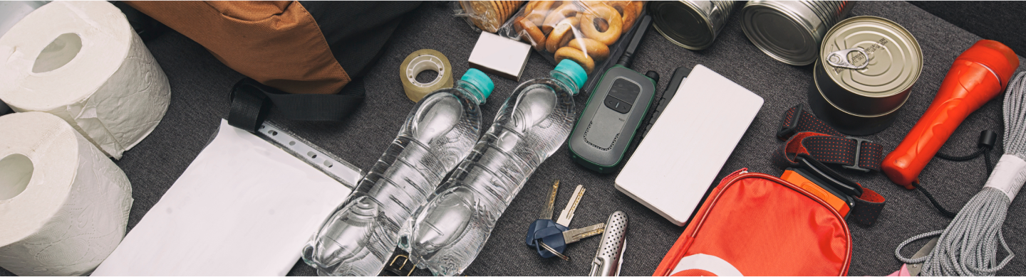 Elements that can go into an emergency go bag, including toilet paper, water, canned food, a flashlight and a first aid kit.