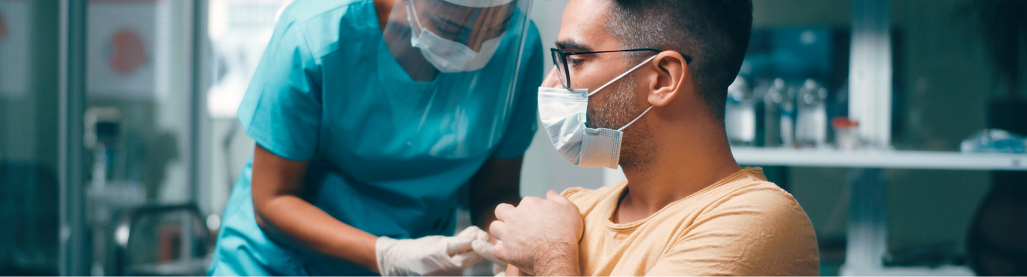 A man wearing a mask, receiving a vaccine